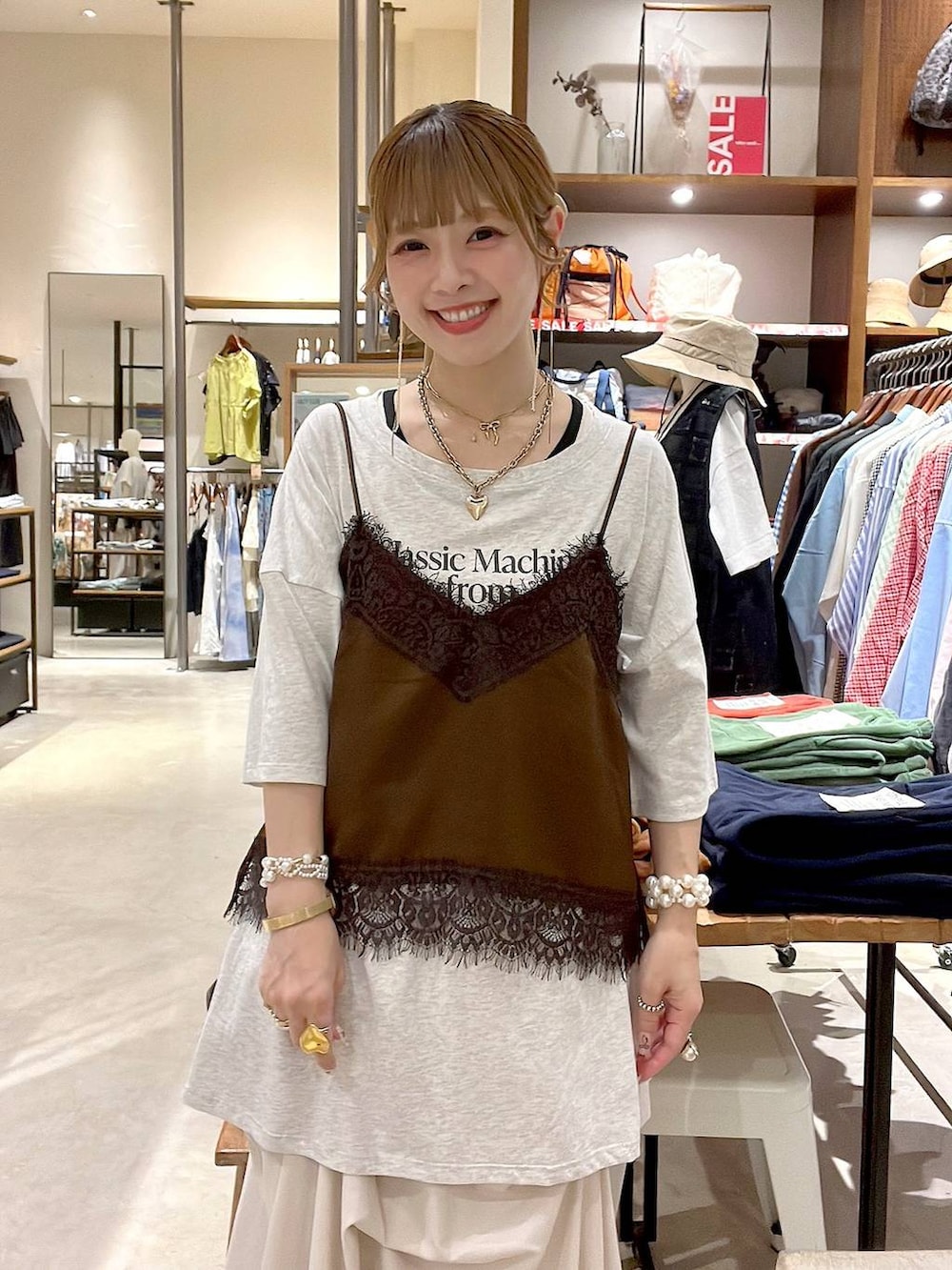 ホワイト系のタンクトップ、ベージュ系のスカート、ブラウン系のキャミソールを着用したレディースの夏コーディネートの2枚目の写真