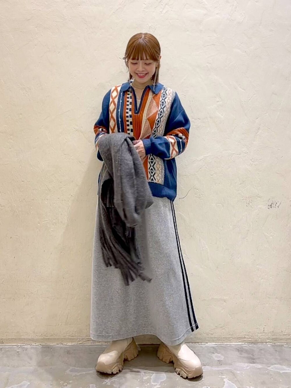 ブルー系のニット/セーター、グレー系のストール/ショール、ブラック系のバレッタ/ヘアクリップを着用したレディースの秋コーディネートの9枚目の写真