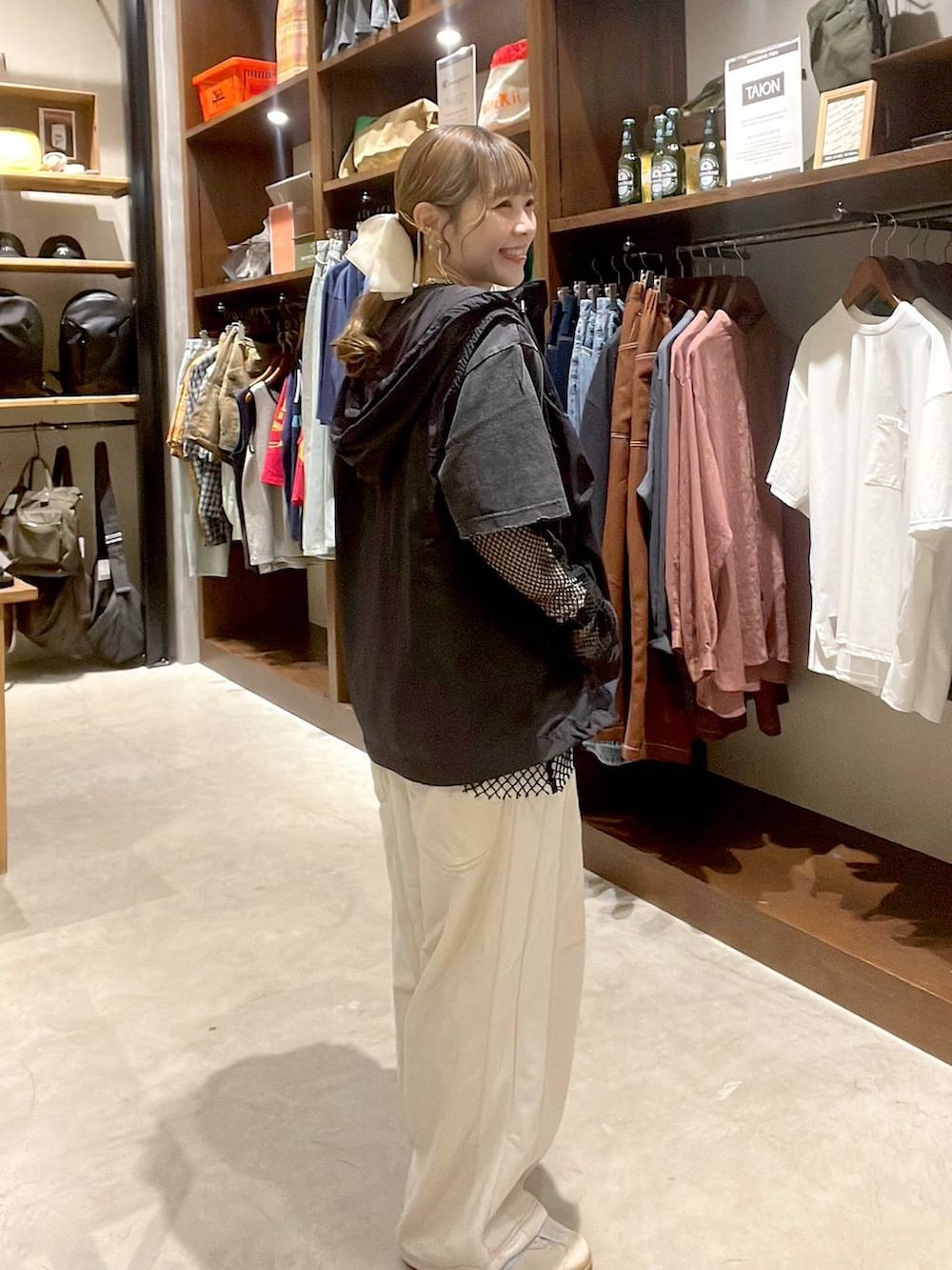 ベージュ系のデニムパンツ、ブラック系のベスト、ブラック系のTシャツ/カットソーを着用したレディースの春コーディネートの3枚目の写真