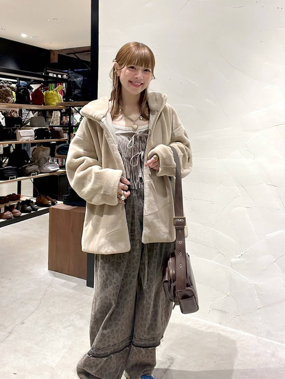 ブラウン系のデニムパンツ、ベージュ系のブルゾン、ブラウン系のショルダーバッグを着用したレディースの冬コーディネートの7枚目の写真