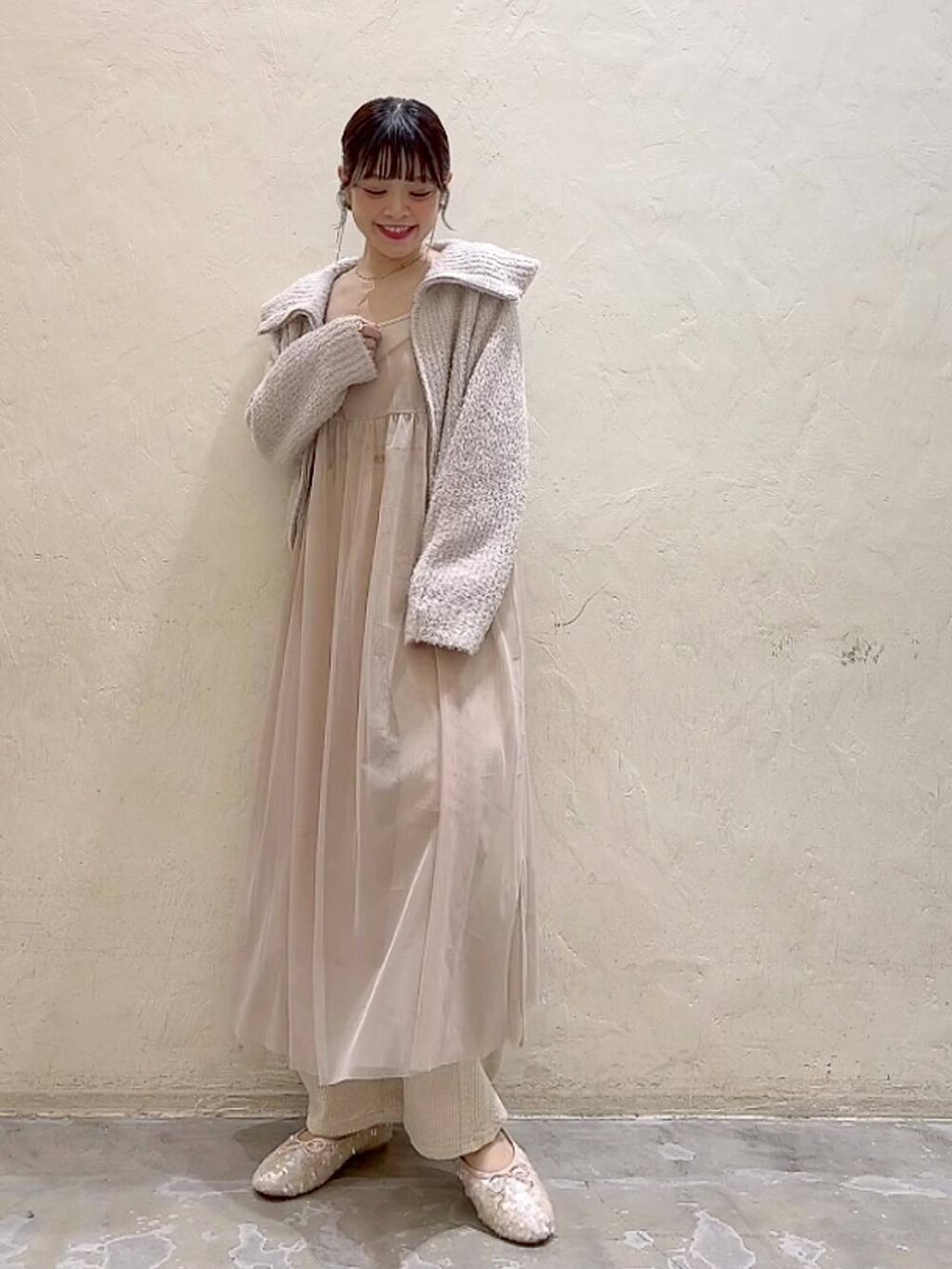 ベージュ系のワンピース、ホワイト系のその他パンツ、ホワイト系のバレエシューズを着用したレディースの冬コーディネートの2枚目の写真