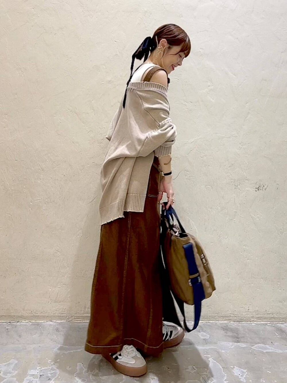 ベージュ系のカーディガン/ボレロ、ブラウン系のスカート、ブラウン系のトートバッグを着用したレディースの秋コーディネートの4枚目の写真