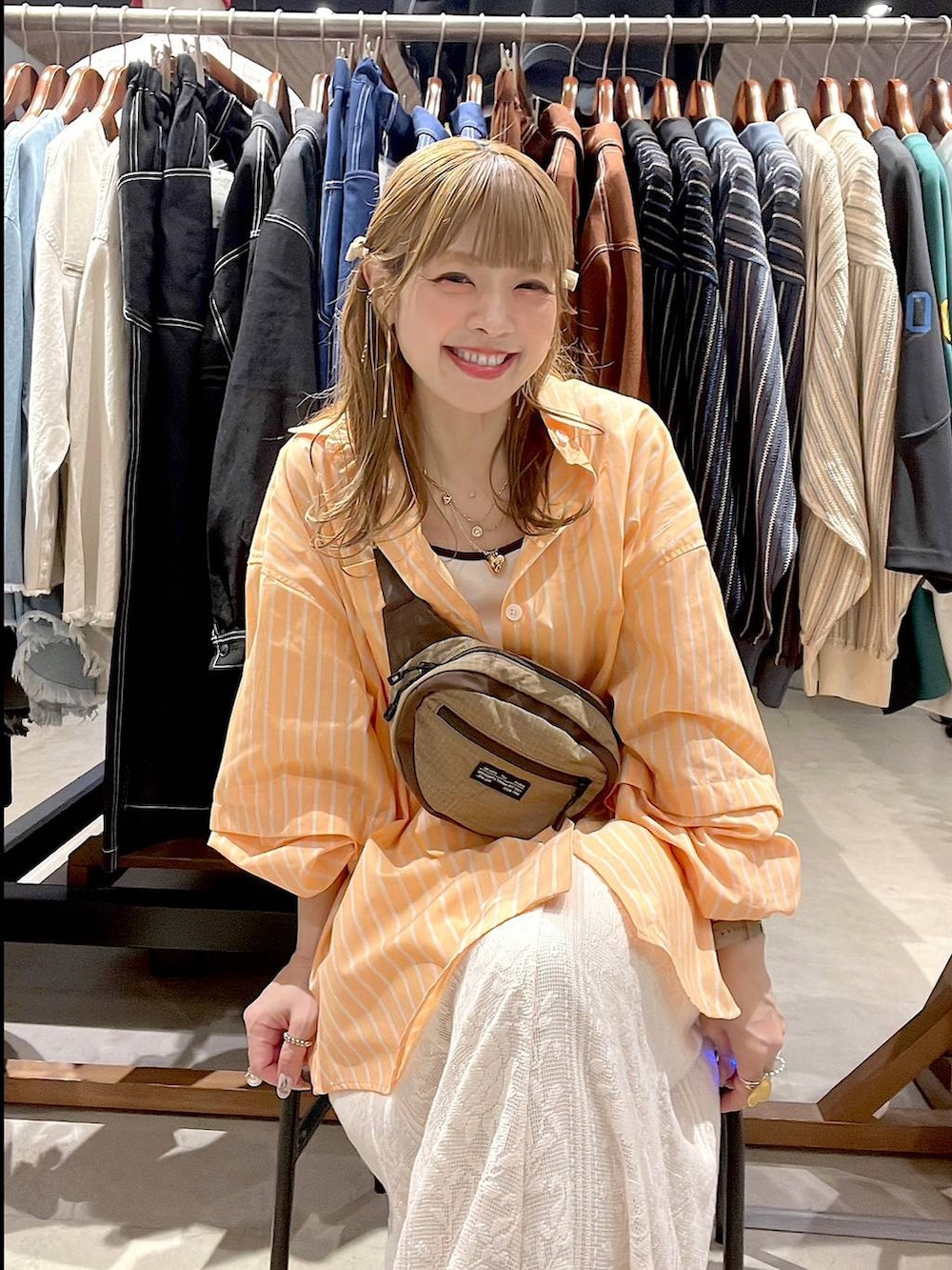 ベージュ系のスニーカー、ベージュ系のボディバッグ/ウエストポーチ、ベージュ系のキャミソールを着用したレディースの春コーディネートの5枚目の写真