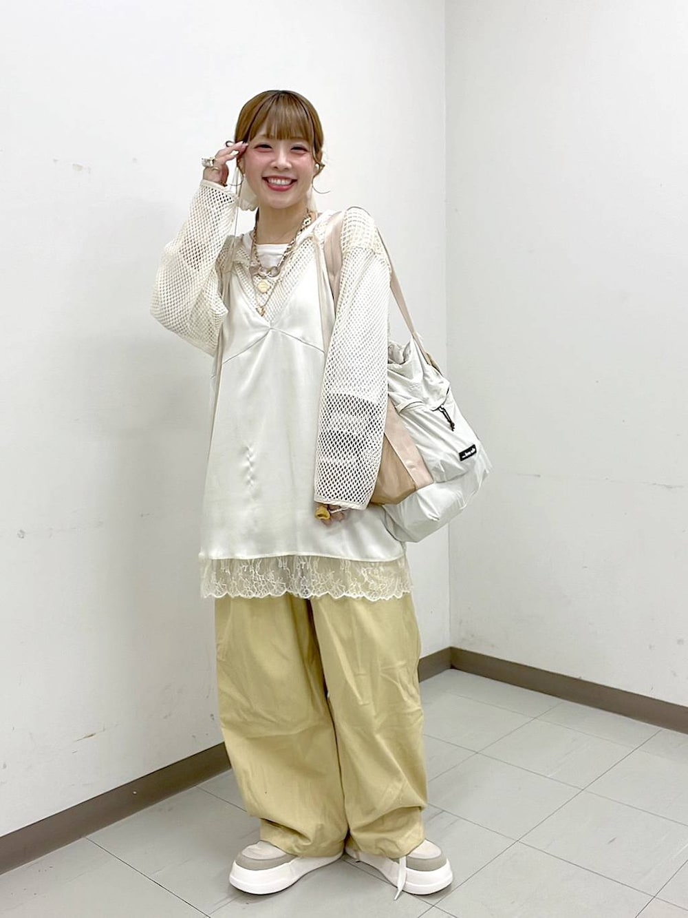 ホワイト系のTシャツ/カットソー、ベージュ系のスニーカー、ベージュ系のトートバッグを着用したレディースの春コーディネートの3枚目の写真