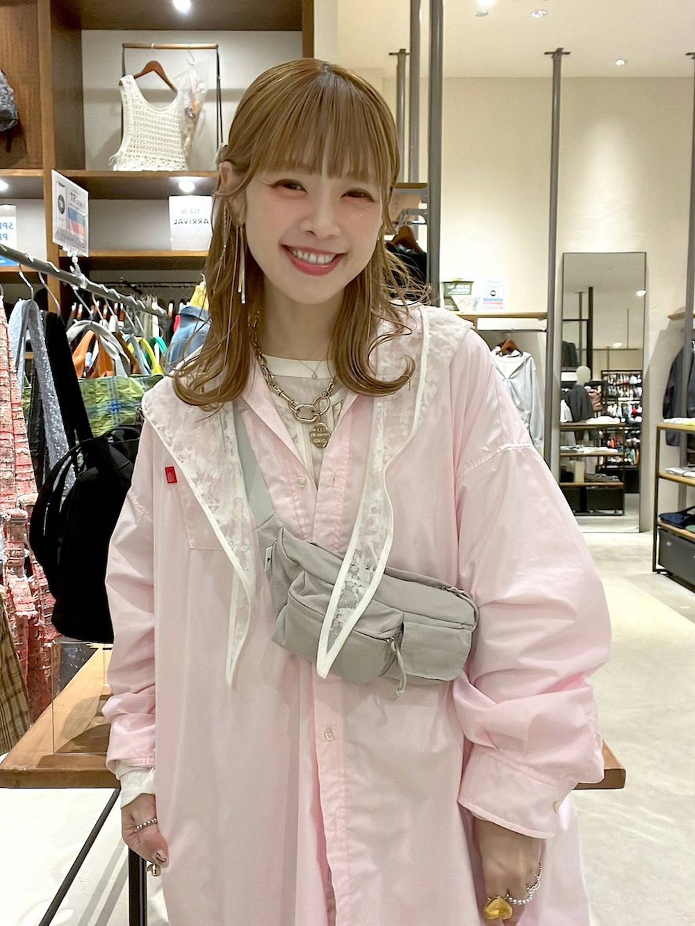 ベージュ系のデニムパンツ、ホワイト系のベスト、ピンク系のシャツ/ブラウスを着用したレディースの春コーディネートの3枚目の写真