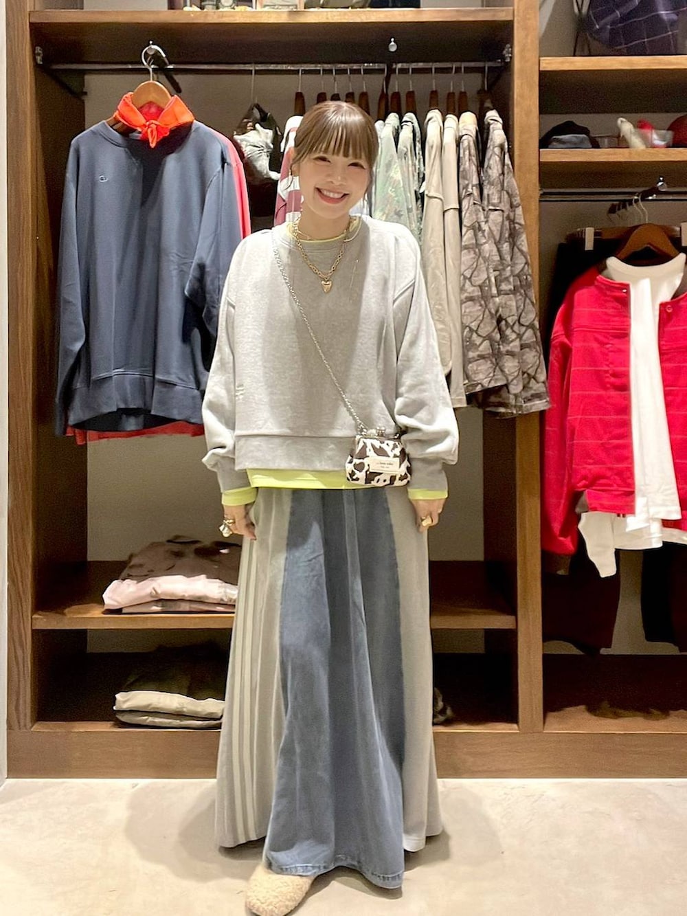 ベージュ系のパンプス、グレー系のスウェット、ブルー系のデニムスカートを着用したレディースの秋コーディネートの3枚目の写真