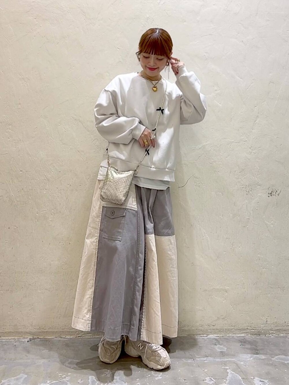 ゴールド系のショルダーバッグ、ホワイト系のTシャツ/カットソー、ホワイト系のその他トップスを着用したレディースの冬コーディネートの8枚目の写真