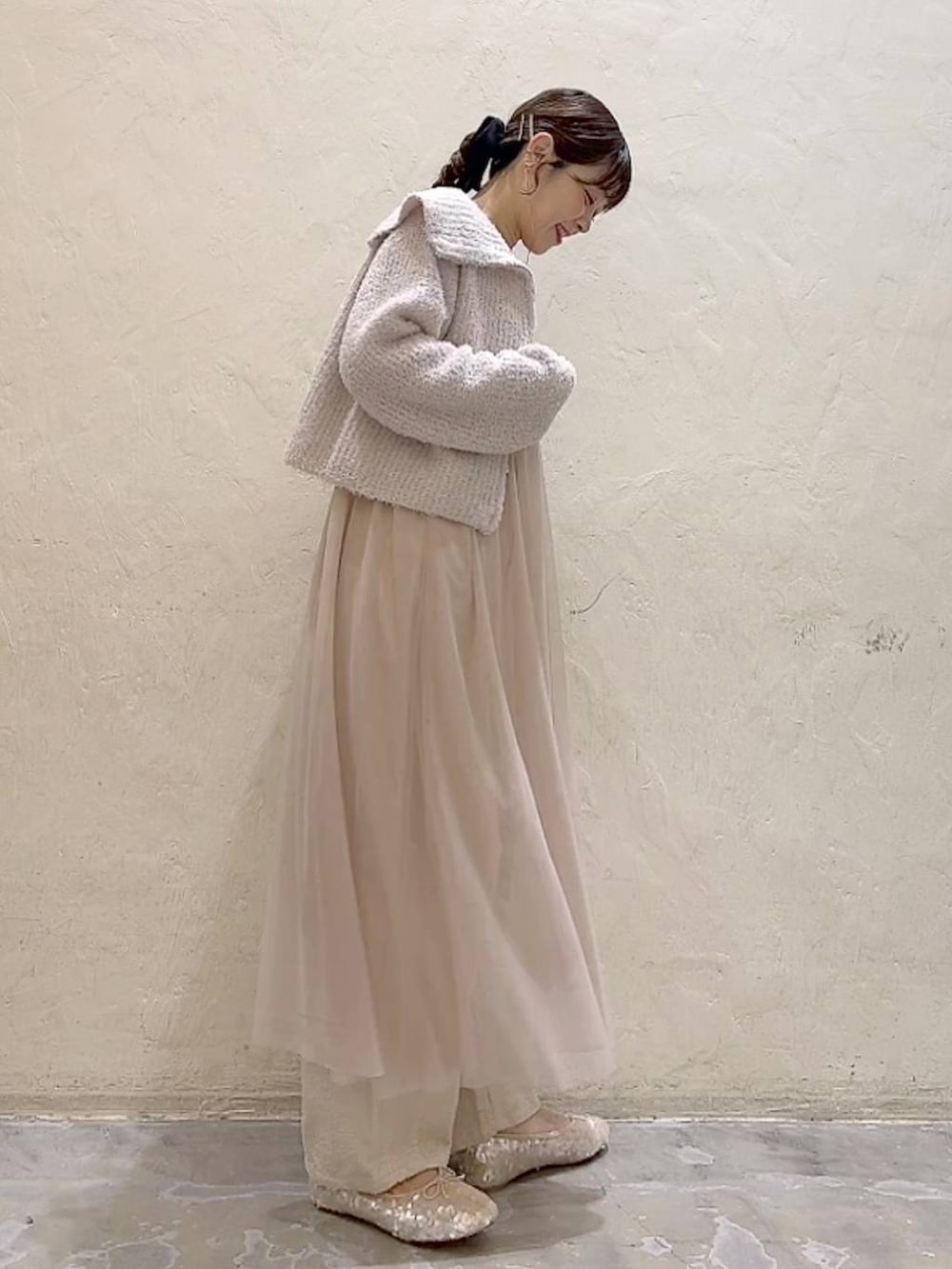 ベージュ系のワンピース、ホワイト系のその他パンツ、ホワイト系のバレエシューズを着用したレディースの冬コーディネートの3枚目の写真