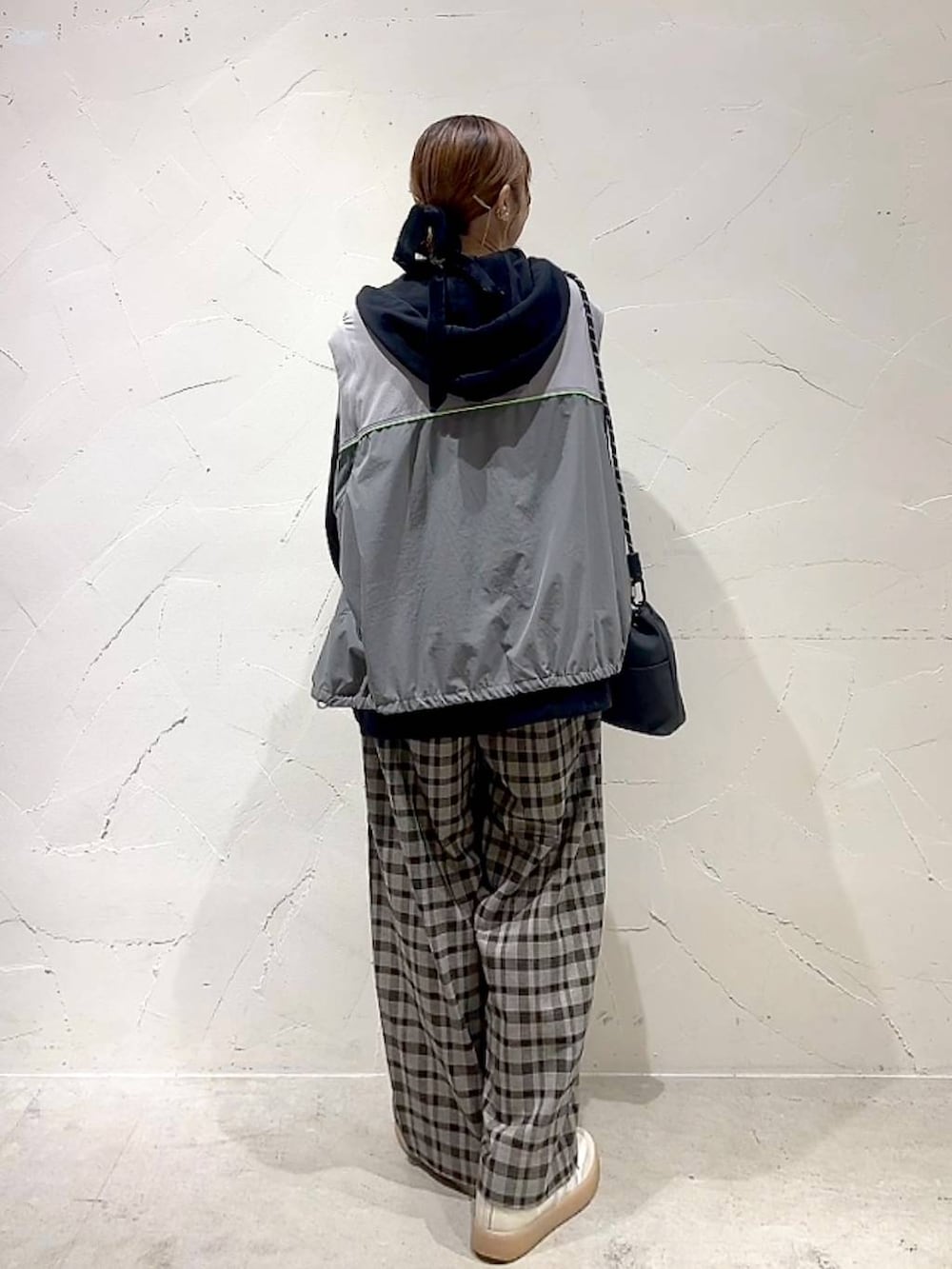 ブラック系のショルダーバッグ、ブラウン系のその他パンツ、イエロー系のネックレスを着用したレディースの秋コーディネートの5枚目の写真