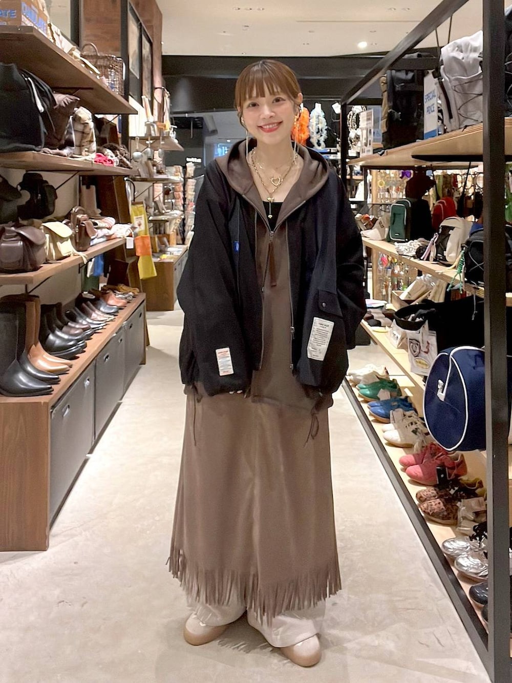 ブラウン系のスカート、ブラウン系のパーカー、ベージュ系のその他パンツを着用したレディースの秋コーディネートの2枚目の写真