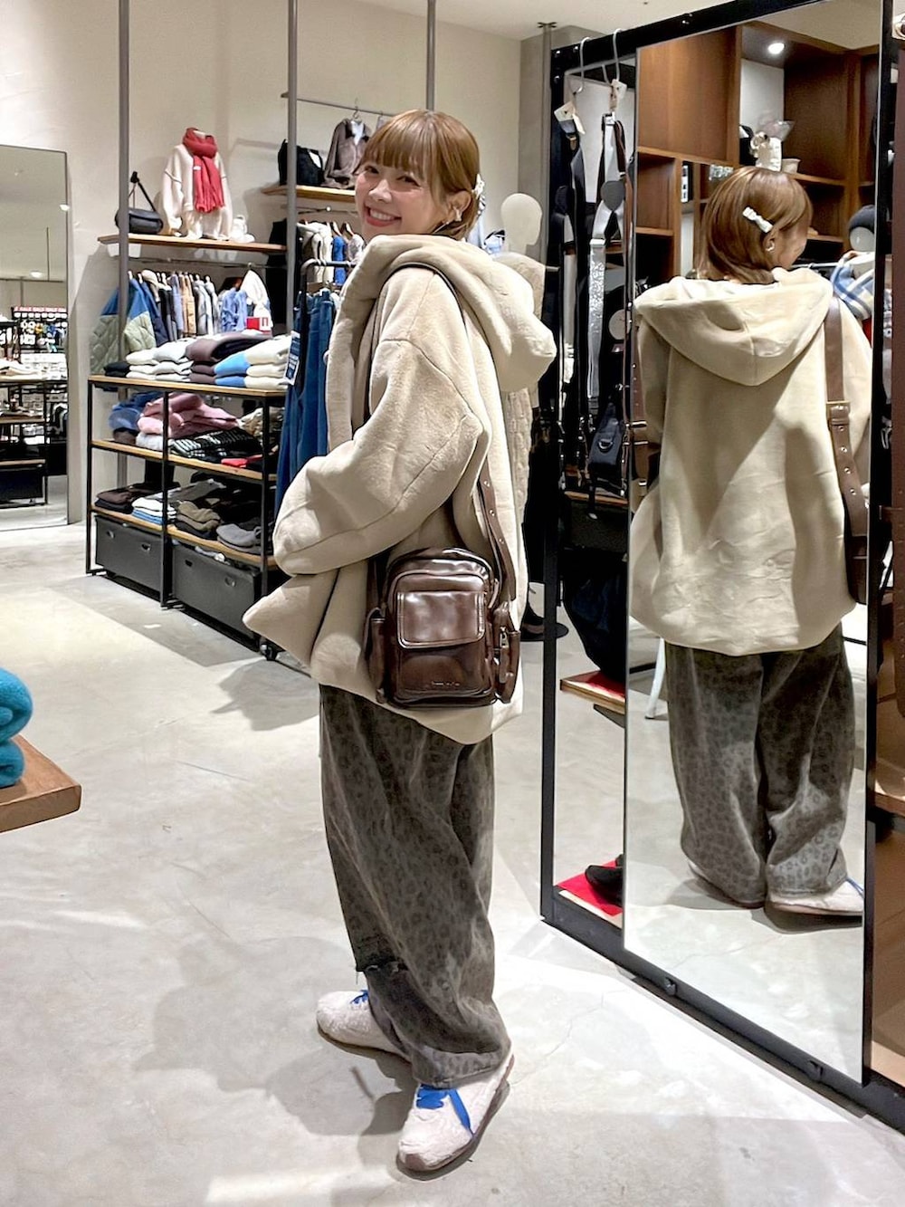 ブラウン系のデニムパンツ、ベージュ系のブルゾン、ブラウン系のショルダーバッグを着用したレディースの冬コーディネートの8枚目の写真