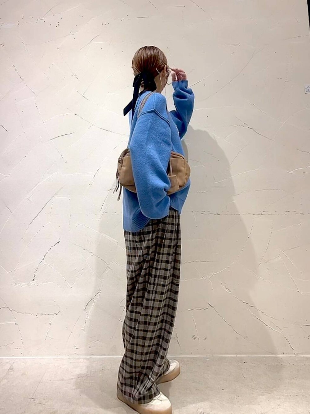 ブラウン系のその他パンツ、ブルー系のニット/セーター、ベージュ系のボストンバッグを着用したレディースの秋コーディネートの4枚目の写真