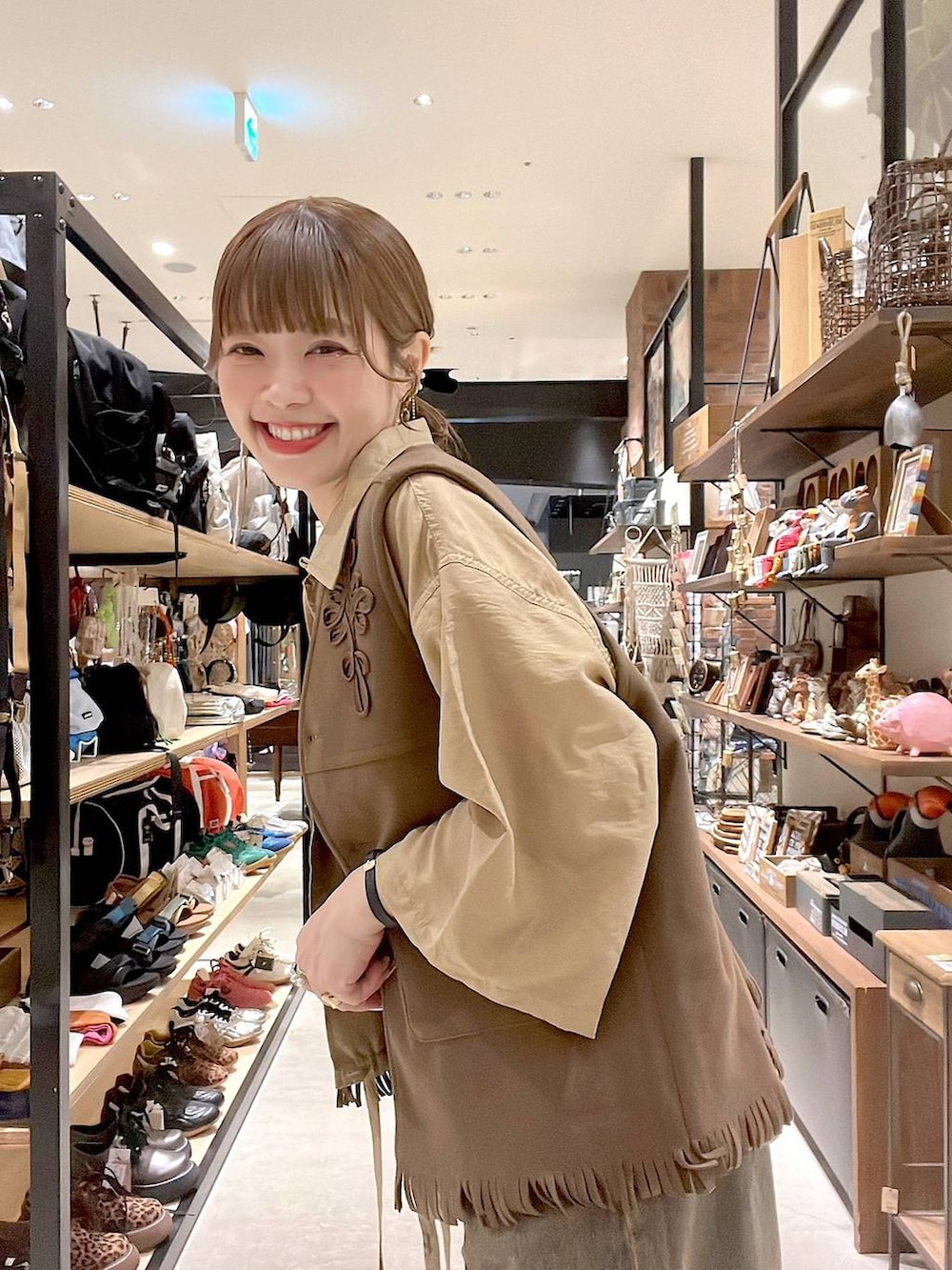 ベージュ系のシャツ/ブラウス、ブラウン系のデニムパンツ、イエロー系のベストを着用したレディースの夏コーディネートの7枚目の写真