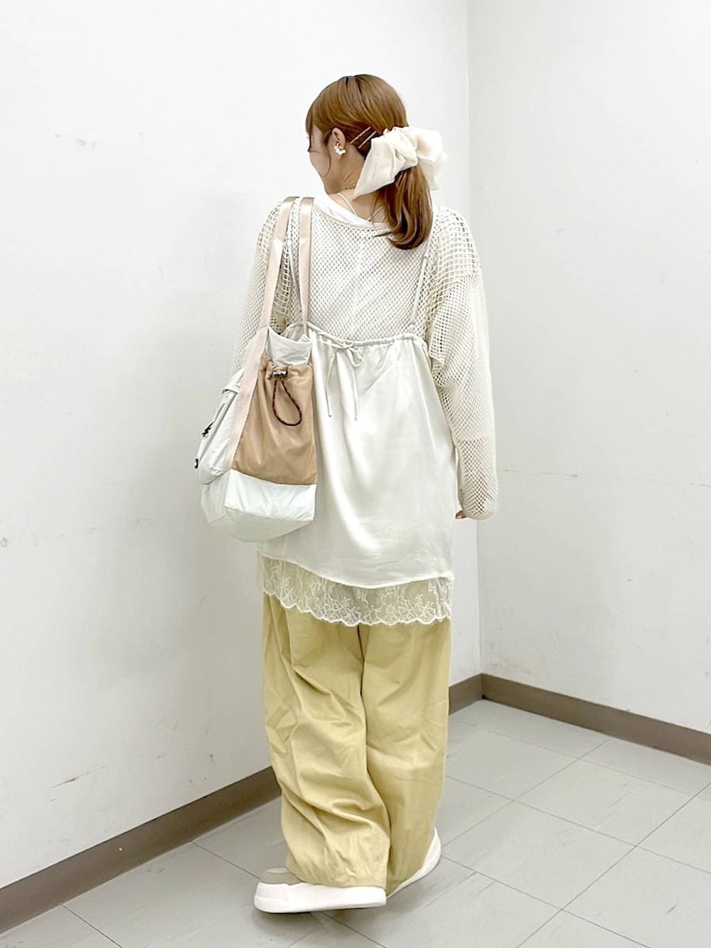 ホワイト系のTシャツ/カットソー、ベージュ系のスニーカー、ベージュ系のトートバッグを着用したレディースの春コーディネートの4枚目の写真