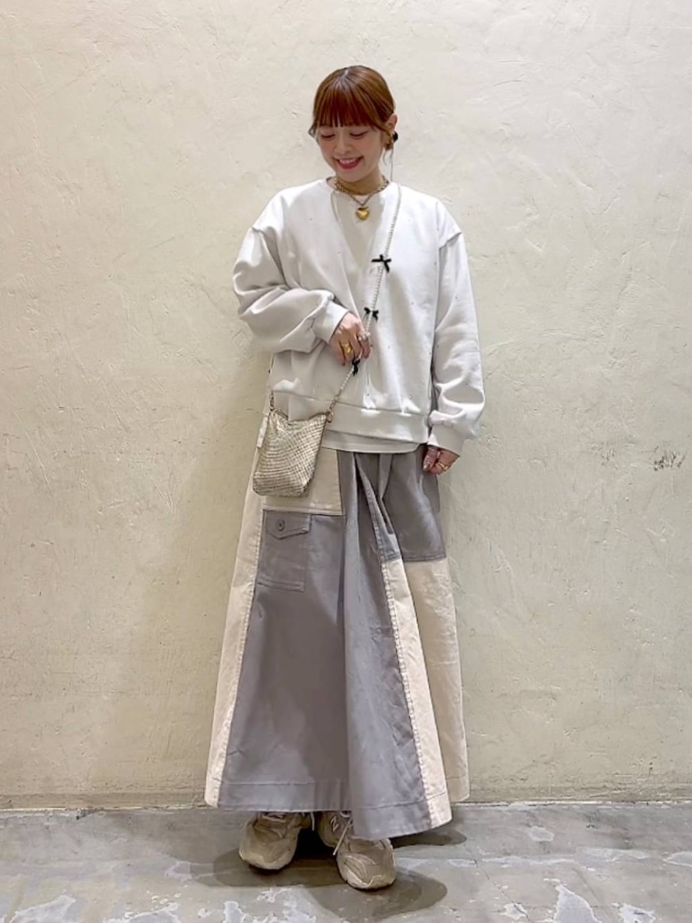 ゴールド系のショルダーバッグ、ホワイト系のTシャツ/カットソー、ホワイト系のその他トップスを着用したレディースの冬コーディネートの2枚目の写真