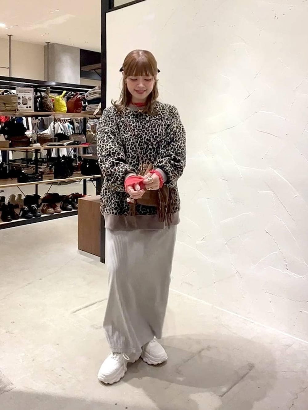 レッド系のTシャツ/カットソー、グレー系のスカート、ベージュ系のスニーカーを着用したレディースの冬コーディネートの6枚目の写真