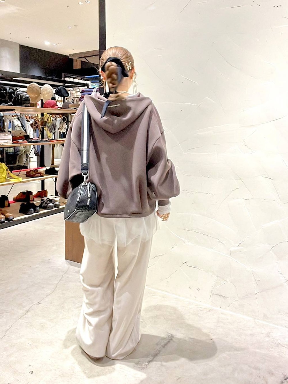 ブラック系のショルダーバッグ、ベージュ系のスニーカー、ベージュ系のその他パンツを着用したレディースの冬コーディネートの6枚目の写真