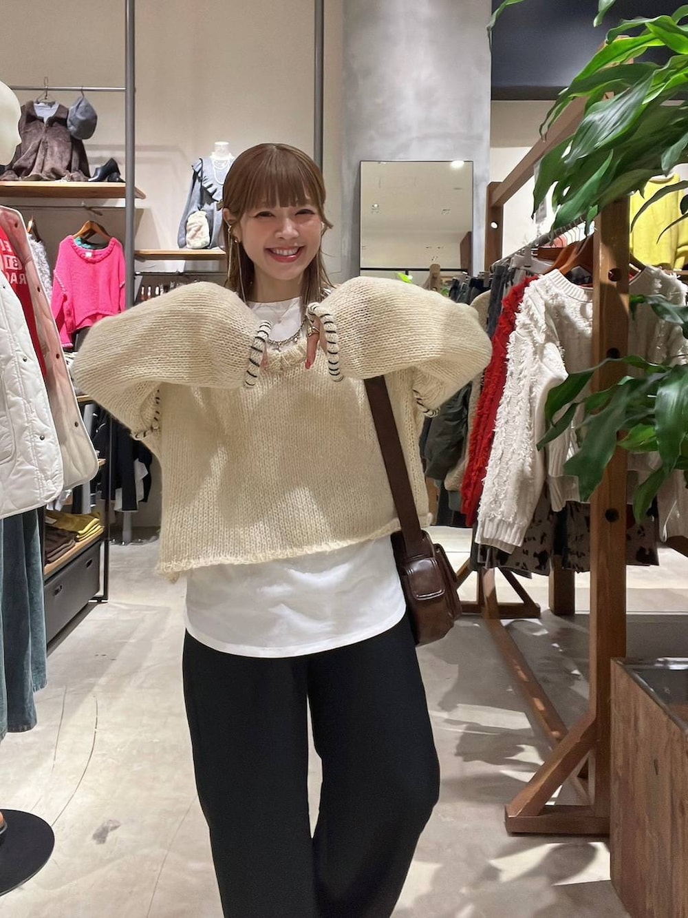 ホワイト系のTシャツ/カットソー、ブラウン系のショルダーバッグ、ベージュ系のスニーカーを着用したレディースの冬コーディネートの5枚目の写真