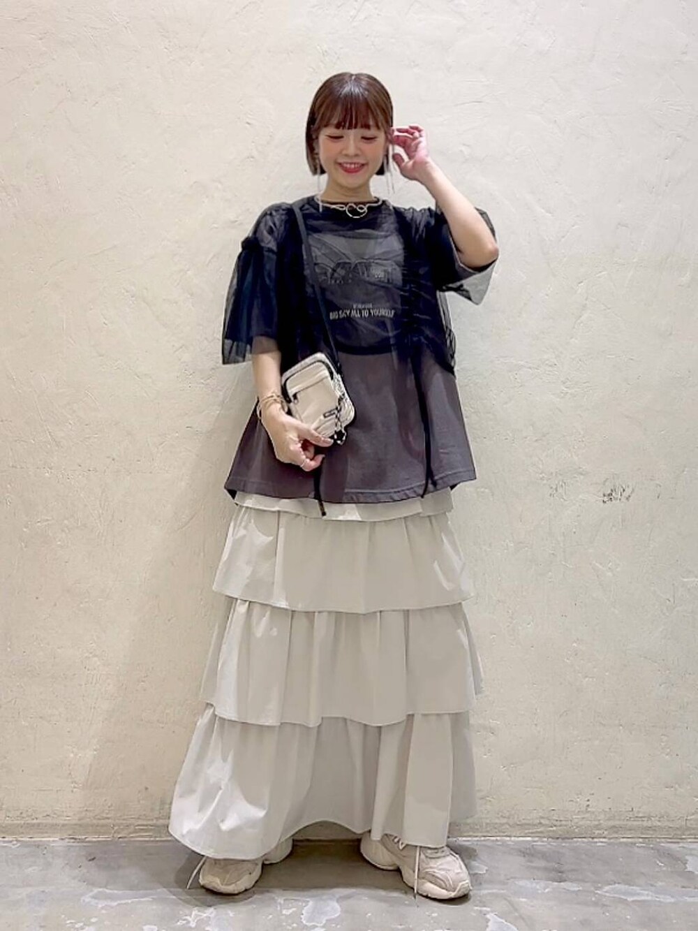 ブラック系のその他トップス、その他のTシャツ/カットソー、ベージュ系のショルダーバッグを着用したレディースの春コーディネートの6枚目の写真