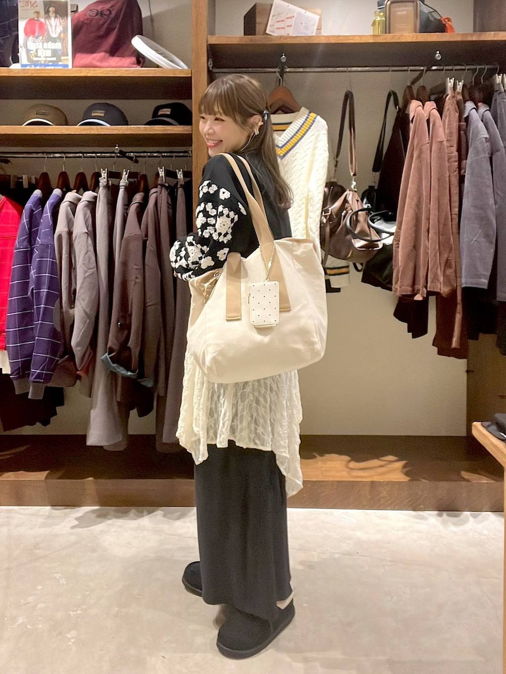 ベージュ系のワンピース、ブラック系のスウェット、ブラック系のモカシン/デッキシューズを着用したレディースの秋コーディネートの9枚目の写真