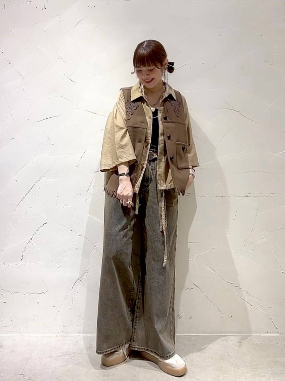ベージュ系のシャツ/ブラウス、ブラウン系のデニムパンツ、イエロー系のベストを着用したレディースの夏コーディネートの9枚目の写真