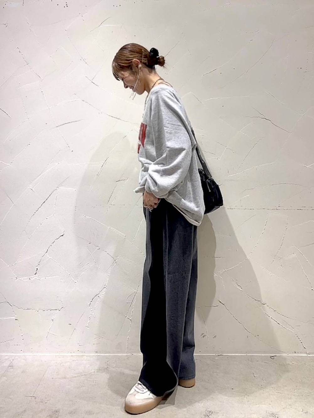 ベージュ系のスウェット、ブラック系のショルダーバッグ、イエロー系のネックレスを着用したレディースの秋コーディネートの7枚目の写真