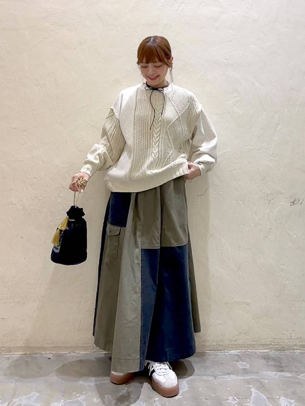 その他のショルダーバッグ、ベージュ系のニット/セーター、グリーン系のスカートを着用したレディースの冬コーディネートの2枚目の写真