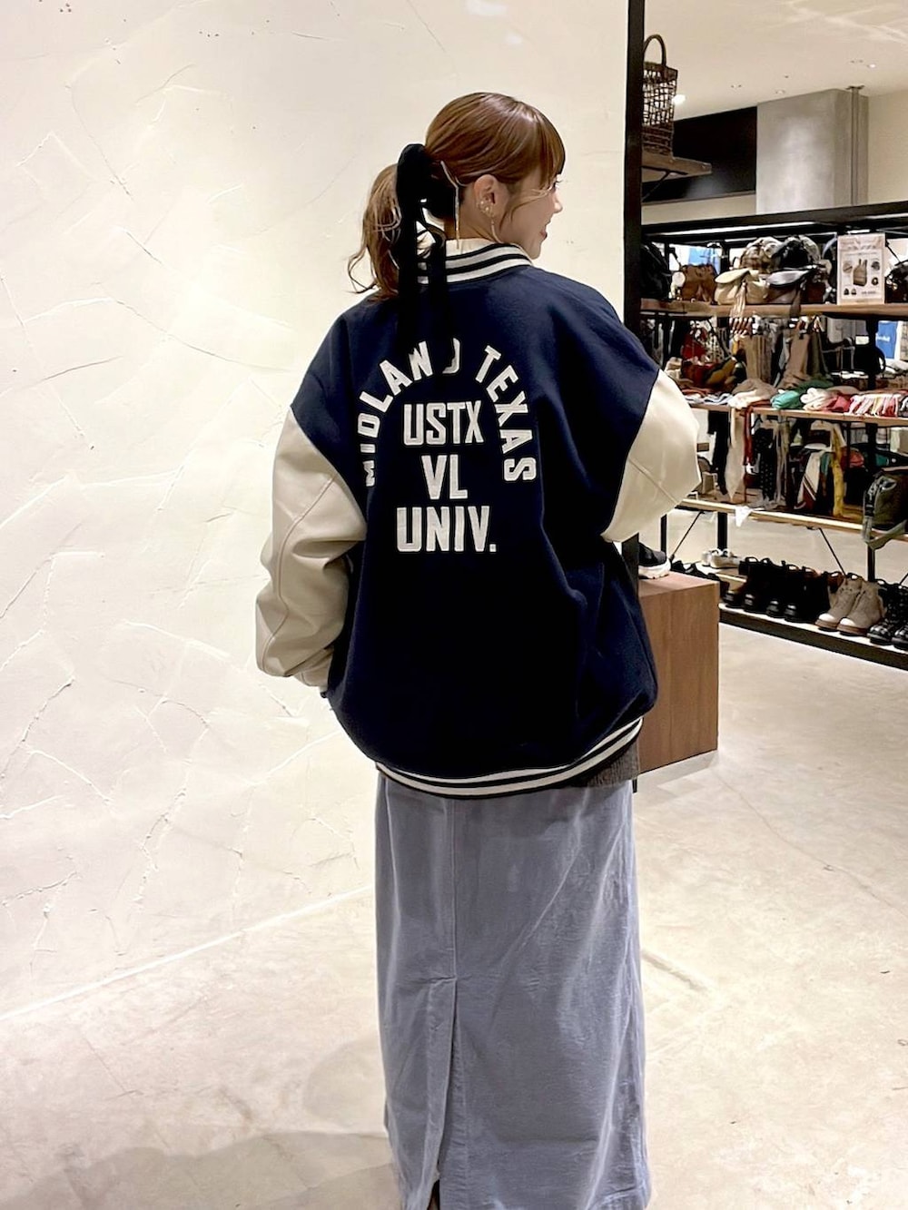 ゴールド系のスニーカー、ブルー系のスカート、ブルー系のブルゾンを着用したレディースの秋コーディネートの3枚目の写真