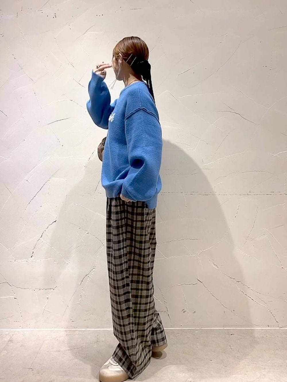 ブラウン系のその他パンツ、ブルー系のニット/セーター、ベージュ系のボストンバッグを着用したレディースの秋コーディネートの6枚目の写真