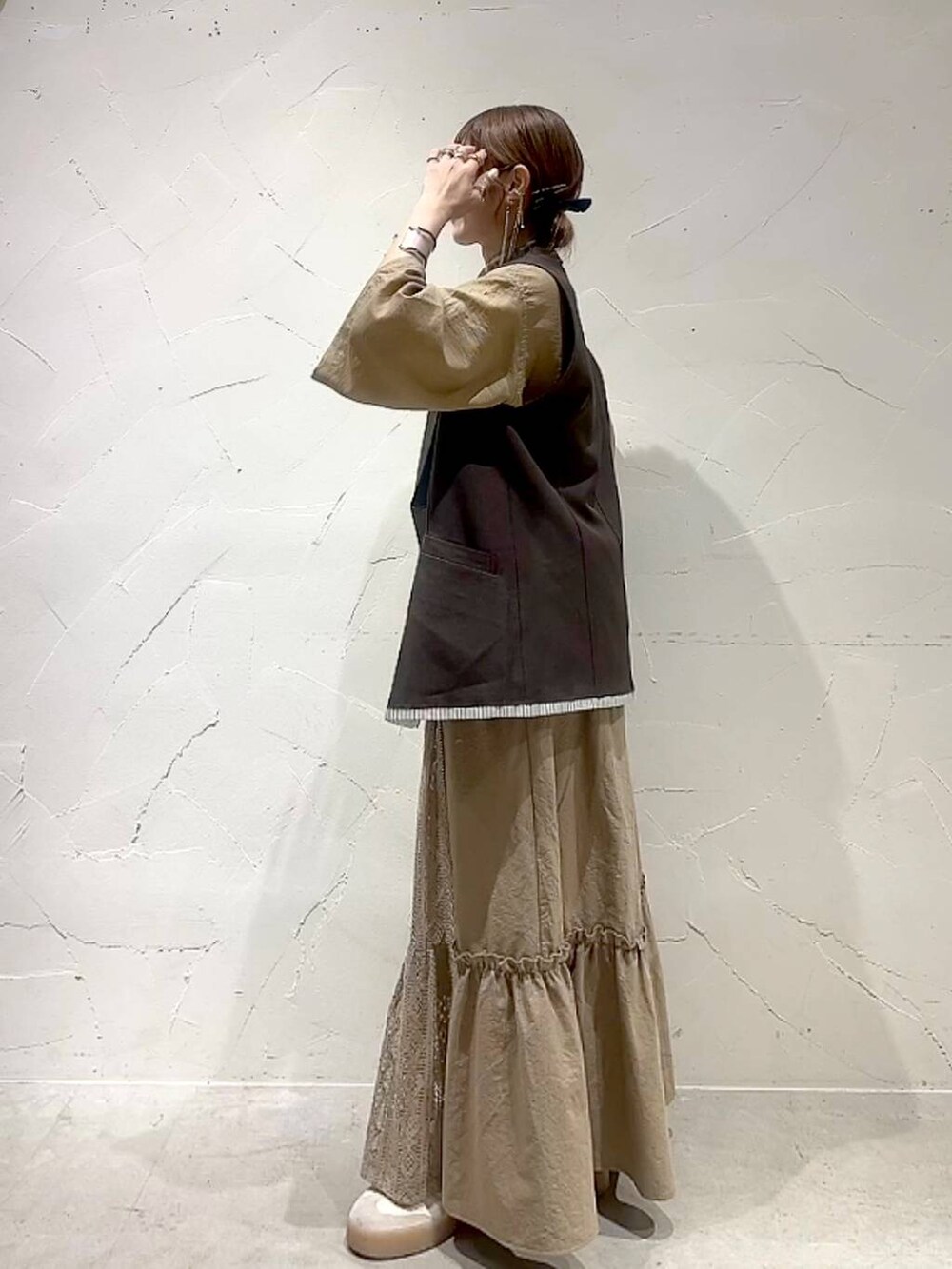 イエロー系のスカート、ブラウン系のベストを着用したレディースの夏コーディネートの8枚目の写真