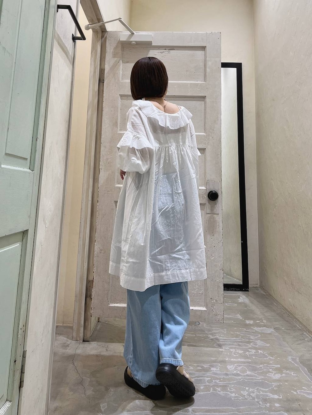 イエロー系のサンダル、ブルー系のその他パンツ、ホワイト系のチュニックを着用したレディースの春コーディネートの2枚目の写真