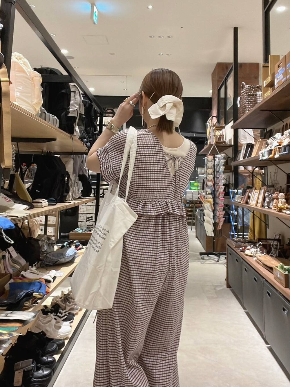 ベージュ系のトートバッグ、イエロー系のアナログ腕時計、ゴールド系のネックレスを着用したレディースの春コーディネートの8枚目の写真