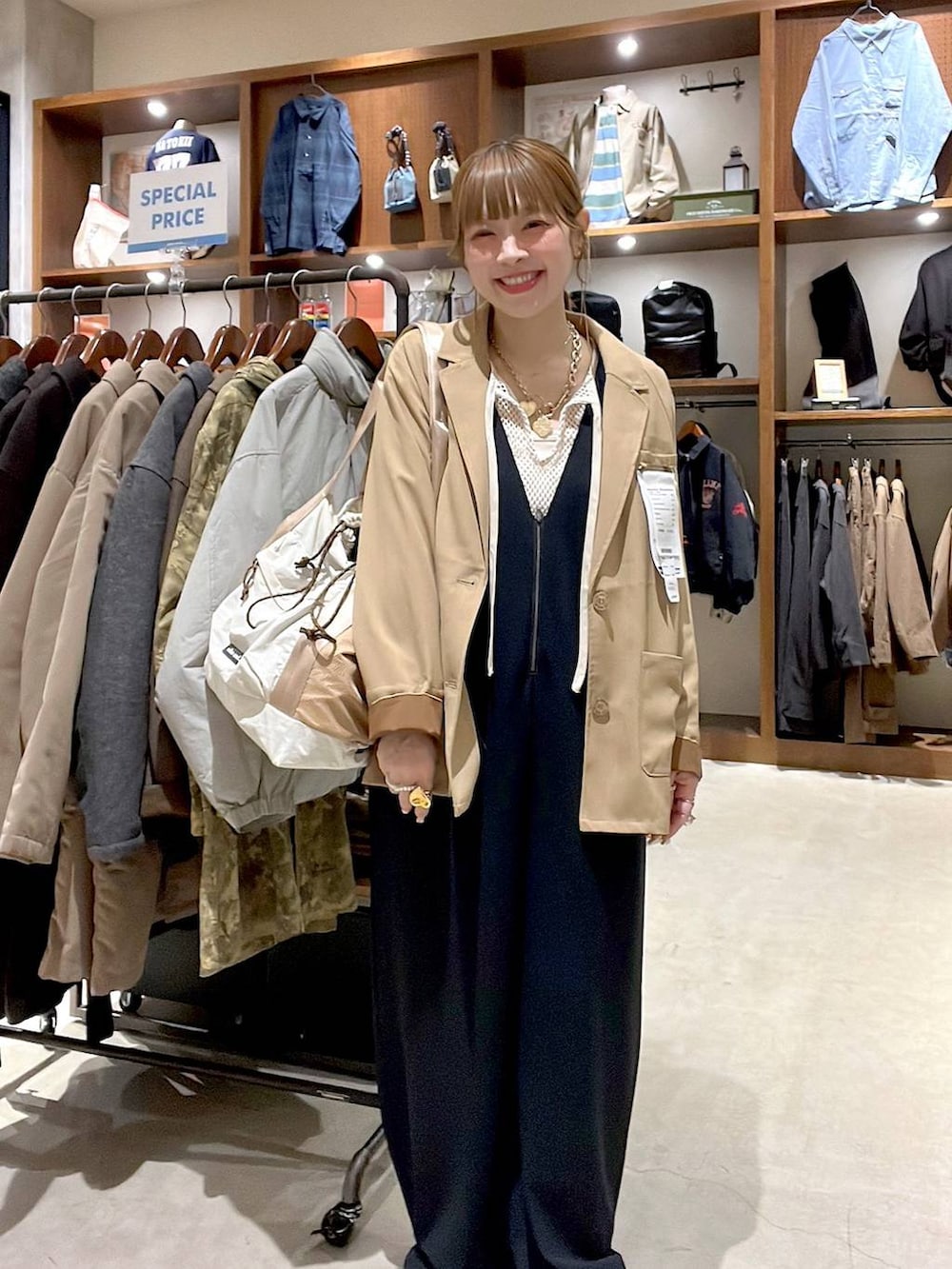 ベージュ系のトートバッグ、ブラック系のサロペット/オーバーオール、ホワイト系のTシャツ/カットソーを着用したレディースの冬コーディネートの9枚目の写真