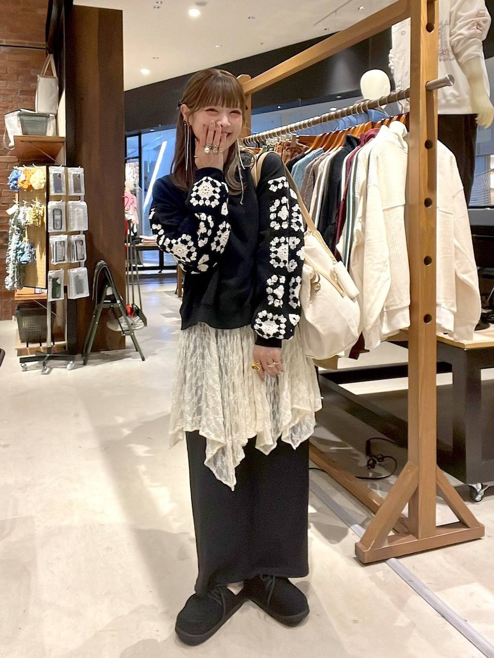 ベージュ系のワンピース、ブラック系のスウェット、ブラック系のモカシン/デッキシューズを着用したレディースの秋コーディネートの6枚目の写真