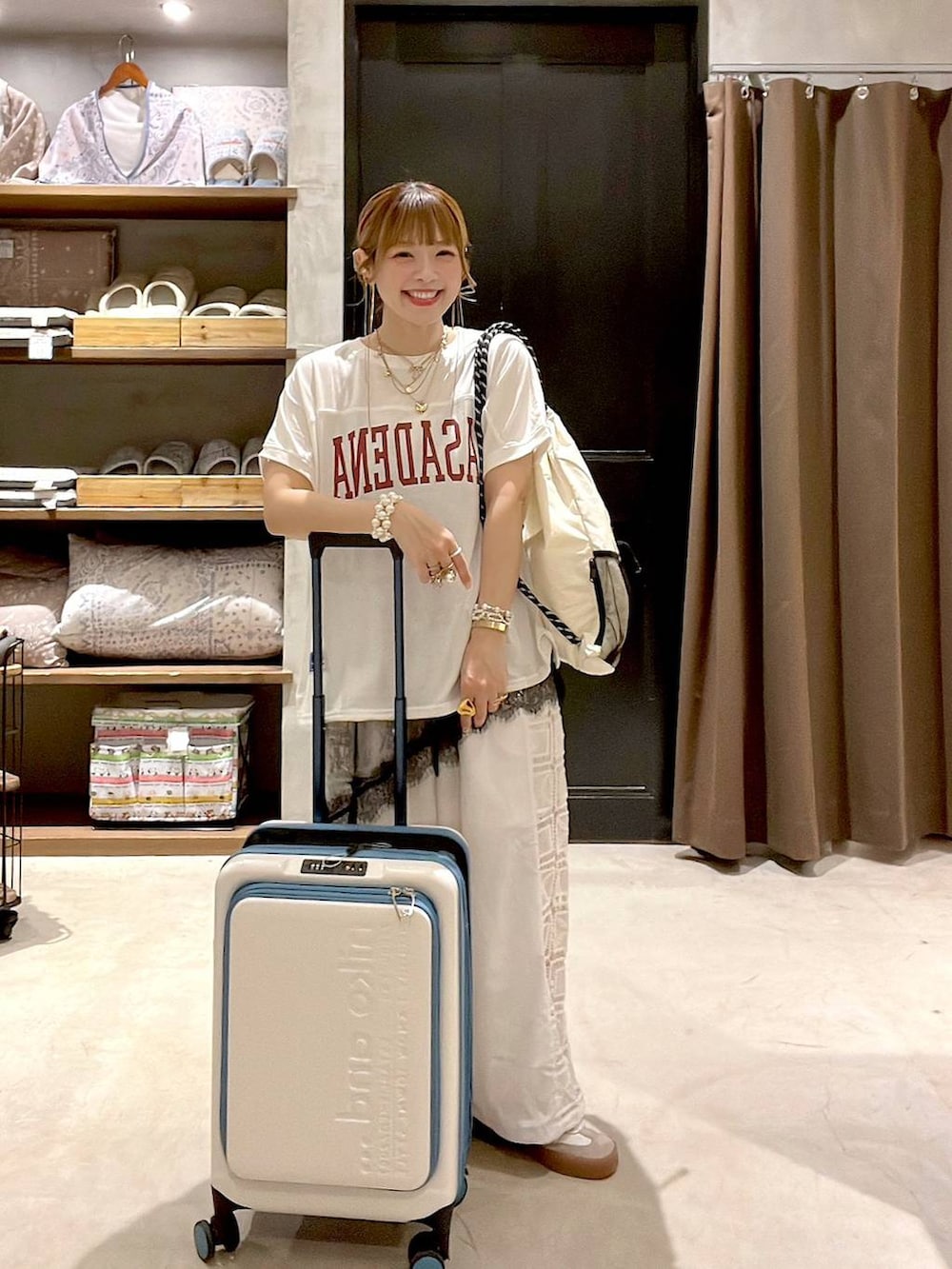 ホワイト系のその他パンツ、ベージュ系のスーツケース/キャリーバッグ、ホワイト系のバックパック/リュックを着用したレディースの夏コーディネートの8枚目の写真