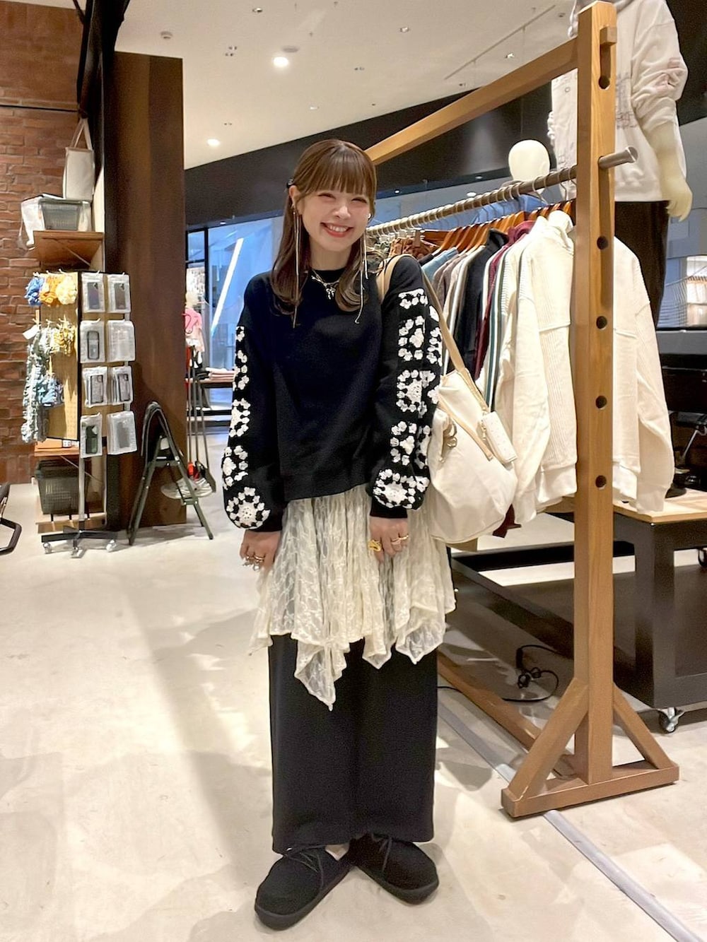 ベージュ系のワンピース、ブラック系のスウェット、ブラック系のモカシン/デッキシューズを着用したレディースの秋コーディネートの4枚目の写真
