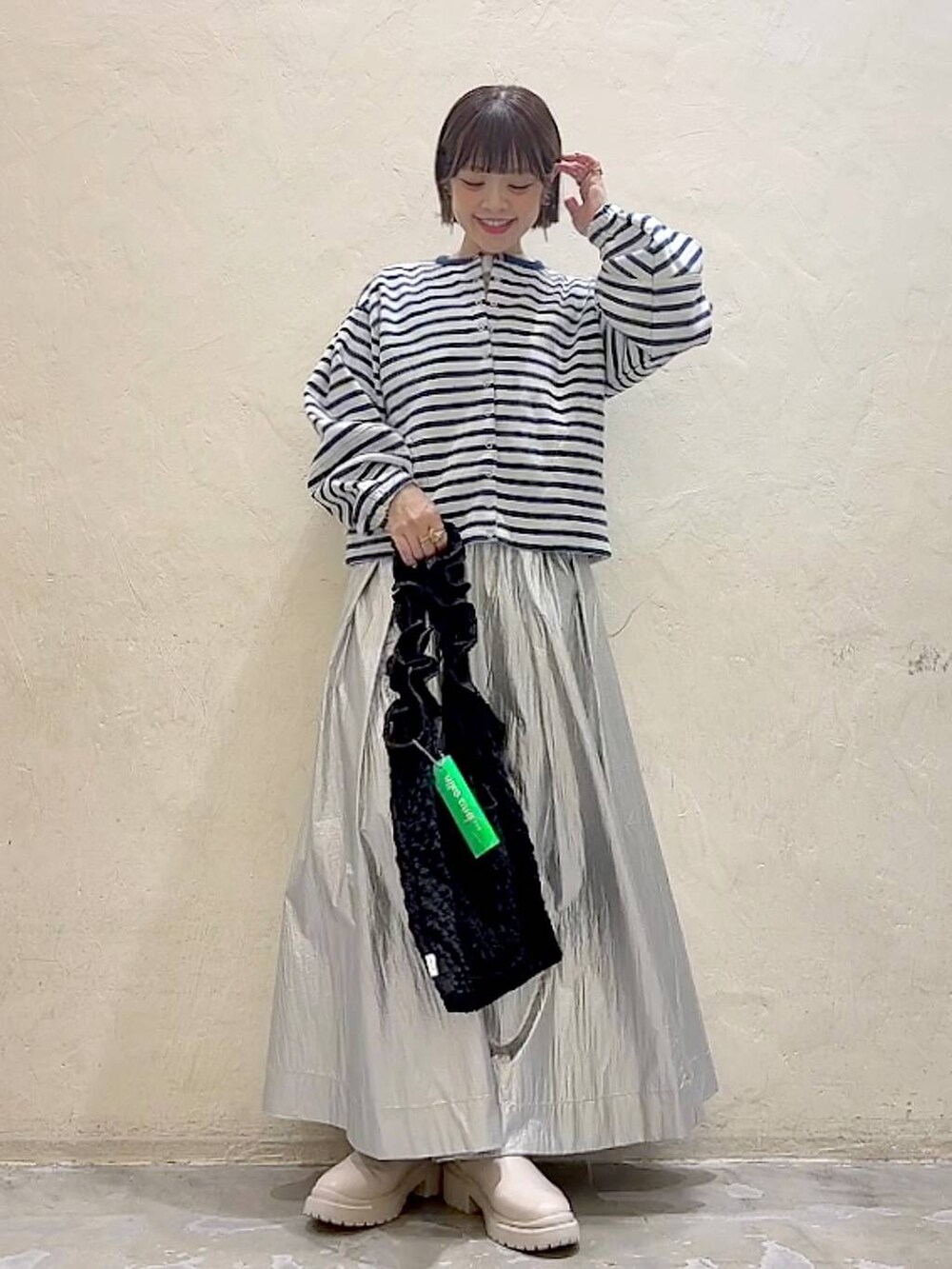 ベージュ系のブーツ、ブラック系のトートバッグ、ホワイト系のTシャツ/カットソーを着用したレディースの冬コーディネートの2枚目の写真