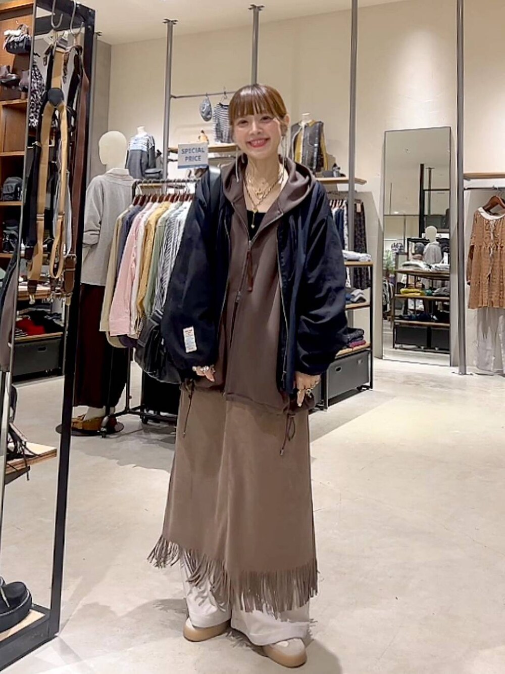 ブラウン系のスカート、ブラウン系のパーカー、ベージュ系のその他パンツを着用したレディースの秋コーディネートの7枚目の写真