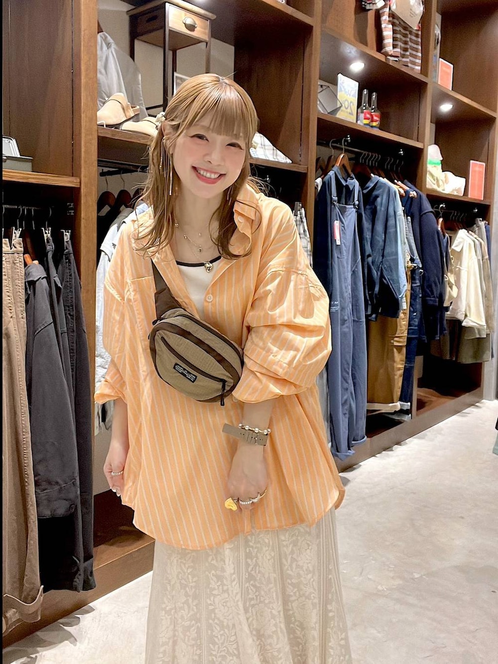 ベージュ系のスニーカー、ベージュ系のボディバッグ/ウエストポーチ、ベージュ系のキャミソールを着用したレディースの春コーディネートの2枚目の写真