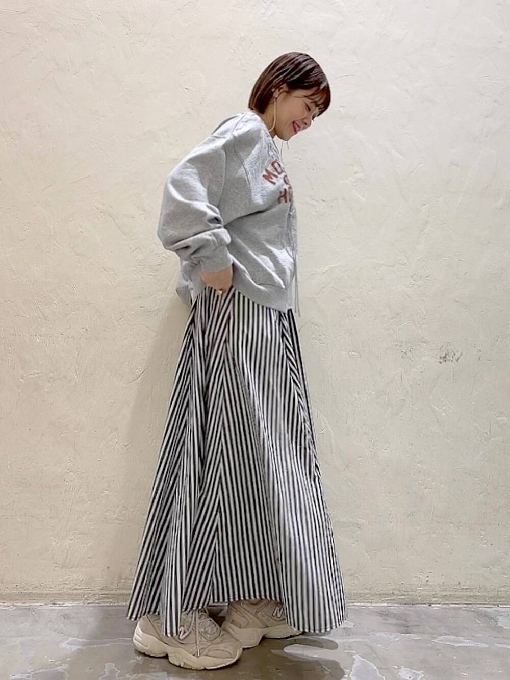 グレー系のTシャツ/カットソー、ブルー系のスカートを着用したレディースの春コーディネートの3枚目の写真