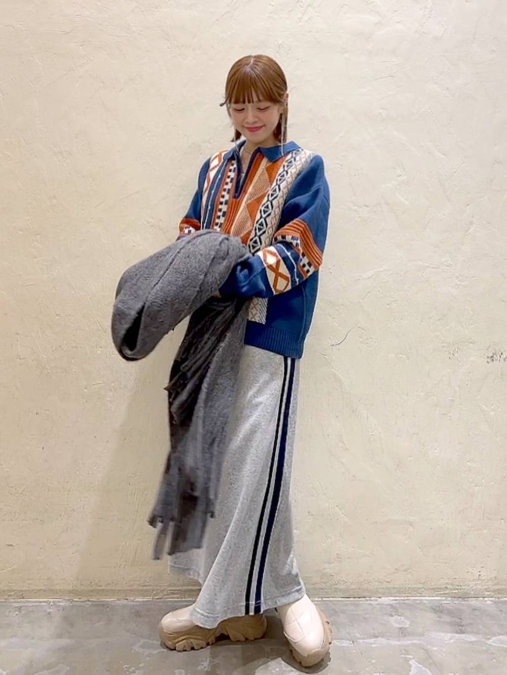 ブルー系のニット/セーター、グレー系のストール/ショール、ブラック系のバレッタ/ヘアクリップを着用したレディースの秋コーディネートの2枚目の写真