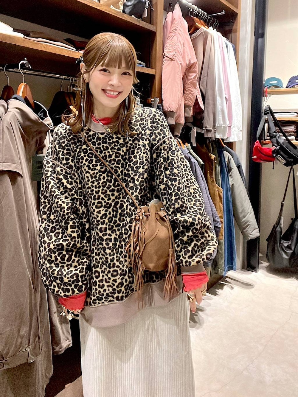 レッド系のTシャツ/カットソー、グレー系のスカート、ベージュ系のスニーカーを着用したレディースの冬コーディネートの4枚目の写真