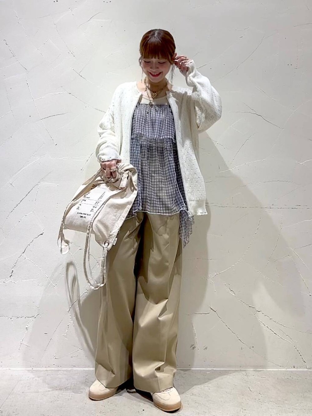 ベージュ系のチノパンツ、ホワイト系のブルゾン、ホワイト系のキャミソールを着用したレディースの春コーディネートの8枚目の写真
