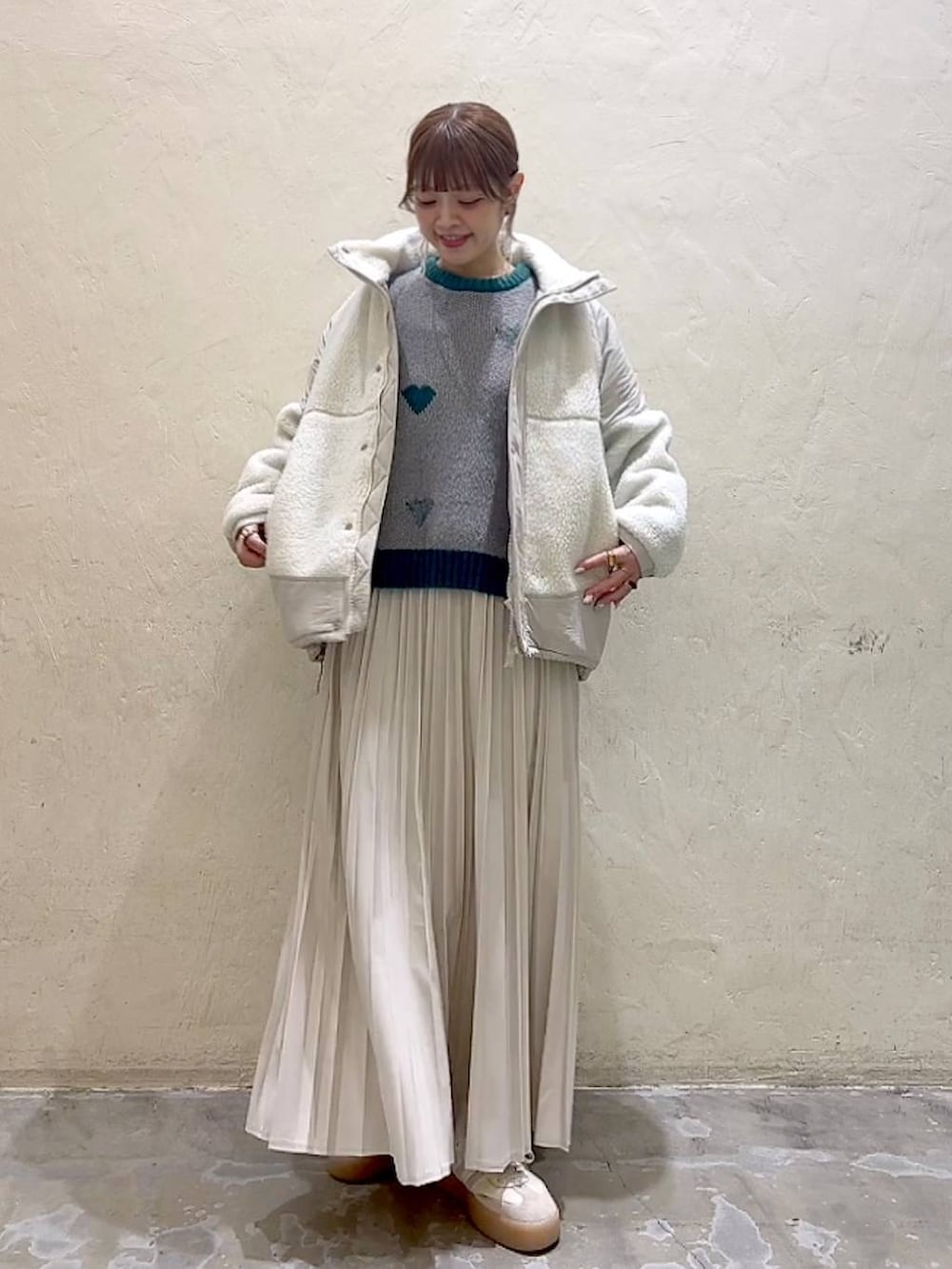 ベージュ系のスカート、ベージュ系のブルゾン、グレー系のニット/セーターを着用したレディースの秋コーディネートの6枚目の写真