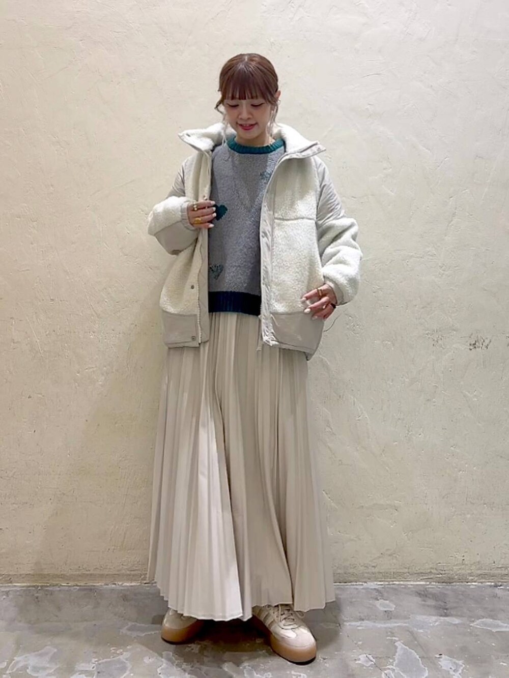 ベージュ系のスカート、ベージュ系のブルゾン、グレー系のニット/セーターを着用したレディースの秋コーディネートの8枚目の写真