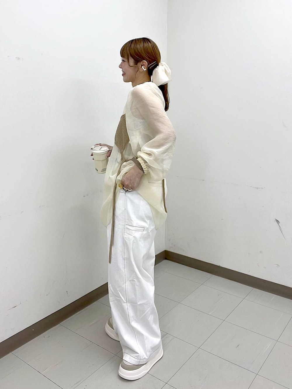 ベージュ系のスニーカー、ゴールド系のリング、グリーン系のアナログ腕時計を着用したレディースの春コーディネートの3枚目の写真