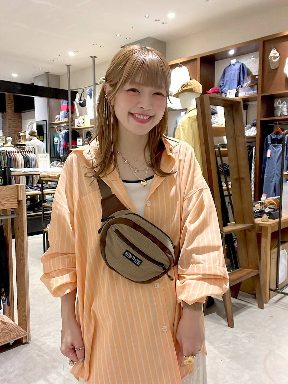 ベージュ系のスニーカー、ベージュ系のボディバッグ/ウエストポーチ、ベージュ系のキャミソールを着用したレディースの春コーディネートの8枚目の写真