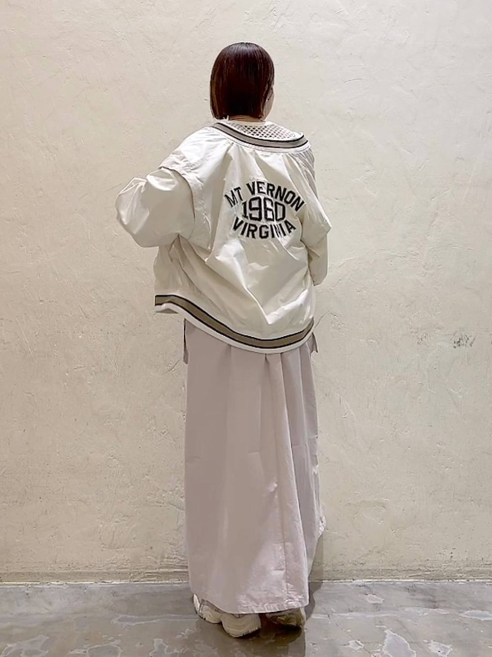 ベージュ系のスタジャン、ベージュ系のワンピース、ホワイト系のTシャツ/カットソーを着用したレディースの春コーディネートの4枚目の写真