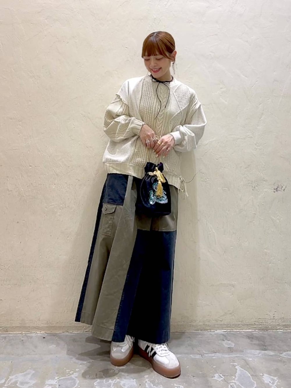 その他のショルダーバッグ、ベージュ系のニット/セーター、グリーン系のスカートを着用したレディースの冬コーディネートの8枚目の写真