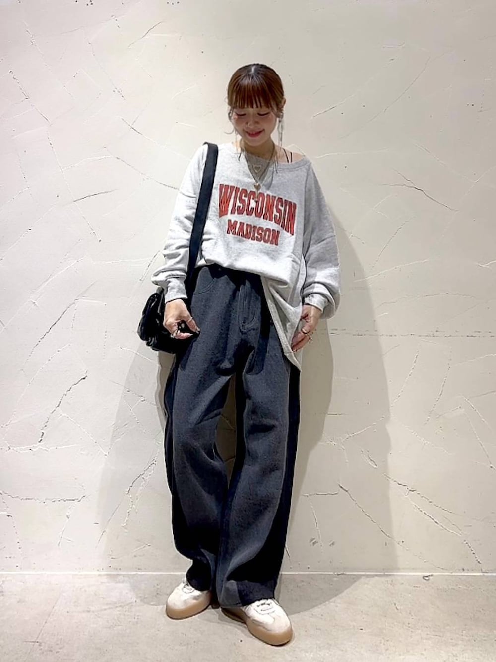 ベージュ系のスウェット、ブラック系のショルダーバッグ、イエロー系のネックレスを着用したレディースの秋コーディネートの2枚目の写真